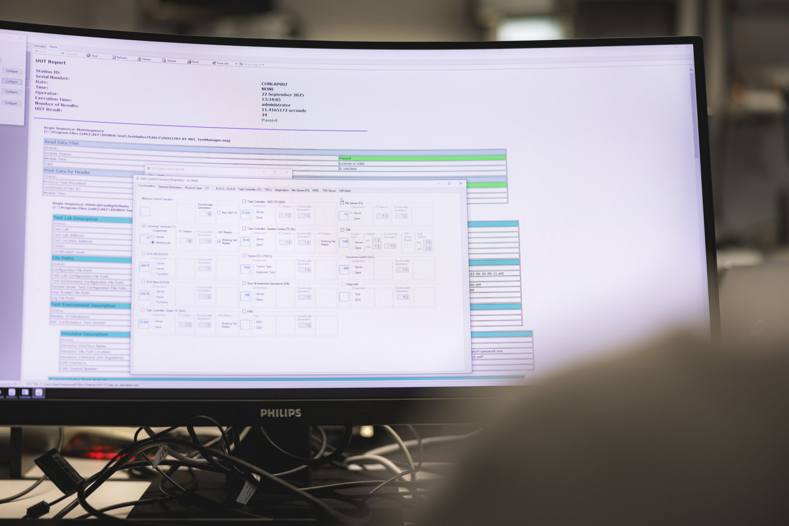 Engineer performing ISOBUS conformance testing and AEF certification validation on laboratory computer at ISOcert:aef